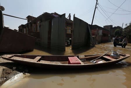 A flood victim stands on the roof of her flooded house in Srinagar September 15, 2014. REUTERS/Adnan Abidi