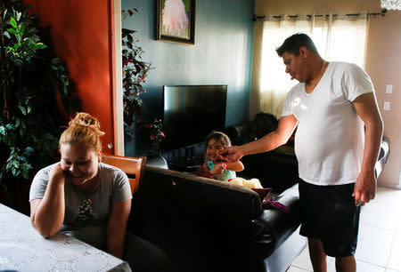 Karla Rojas, 26, (L) is interviewed about lead paint that was found in her brother Raul Zavala Rojas' (R) home while she was living there as Raul playfully pinches a cheek of his three-year old niece Kendra Nicole Rojas in the Historic South Central neighborhood of Los Angeles, California, United States April 5, 2017. REUTERS/Danny Moloshok