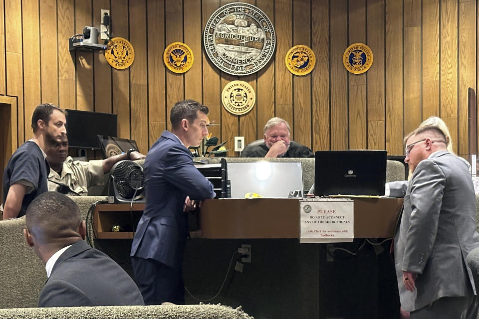 U.S. Army veteran Karl Loucks, left, watches a police video on a computer monitor during a court hearing, Tuesday, July 9, 2024, in Memphis, Tenn., about first-degree murder charges filed against him in the fatal shooting of a homeless man. Also pictured are defense attorney Blake Ballin, left, next to Loucks, Shelby County Judge Bill Anderson, center, and Memphis Police Department Sgt. Jeramy Cline, right. (AP Photo/Adrian Sainz)