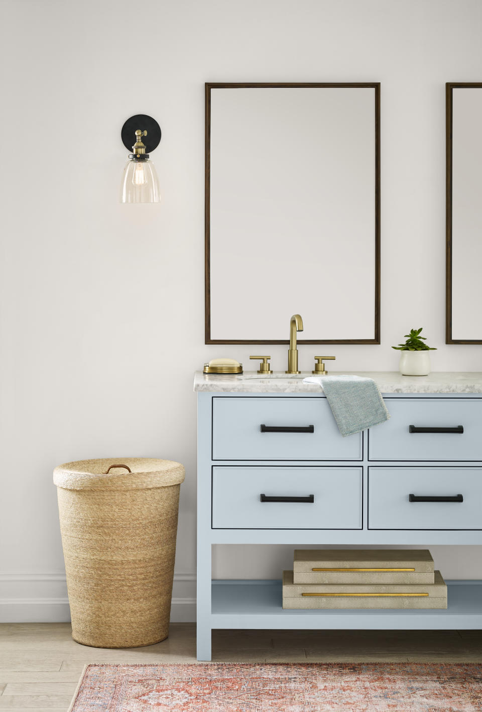 A bathroom with white walls and a double vanity painted in a pale pastel blue