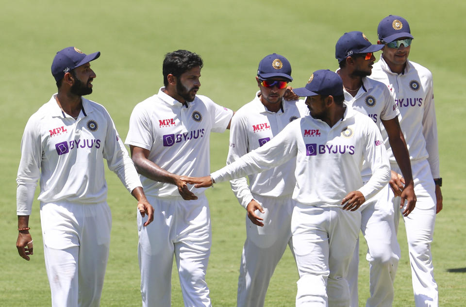 India's Shardul Thakur, second left, is congratulated by teammate Rishabh Pant after taking the wicket of Australia's Tim Paine during play on day two of the fourth cricket test between India and Australia at the Gabba, Brisbane, Australia, Saturday, Jan. 16, 2021. (AP Photo/Tertius Pickard)