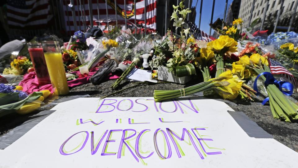 FILE - In this April 17, 2013 photograph, flowers and signs adorn a barrier, two days after two explosions killed three and injured hundreds, at Boylston Street near the of finish line of the Boston Marathon at a makeshift memorial for victims and survivors of the bombing. A federal appeals court has overturned the death sentence of Dzhokhar Tsarnaev in the 2013 Boston Marathon bombing, Friday, July 31, 2020, saying the judge who oversaw the case didn't adequately screen jurors for potential biases. (AP Photo/Charles Krupa, File)