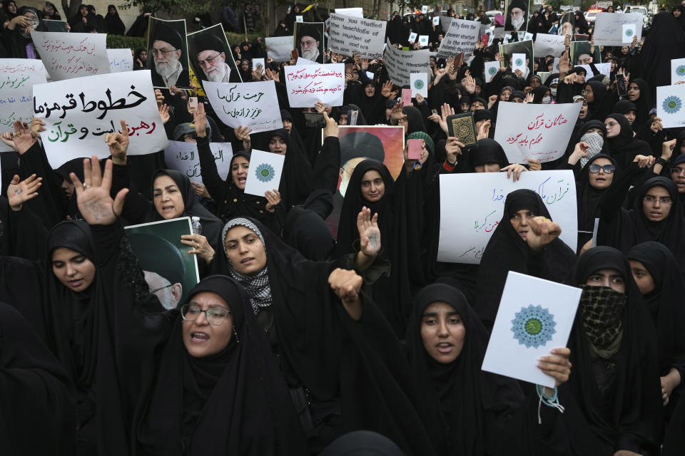 Protesters chant slogans against Sweden in front of the embassy in Tehran, Iran, Friday, July 21, 2023. Thousands of people took to the streets in a handful of Muslim-majority countries Friday to express their outrage at the desecration of a copy of the Quran in Sweden, a day after protesters stormed the country's embassy in Iraq. The placard at left reads in Farsi: " Our red lines are the supreme leader and the Quran". (AP Photo/Vahid Salemi)