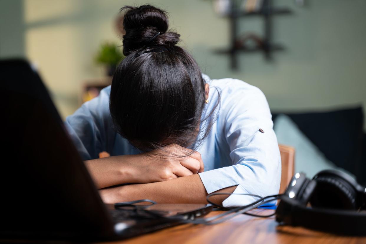 young Business woman sleeping by closing laptop while working, concept of new normal burnout, over or late night work at home during coronavirus covid-19 pandemic.