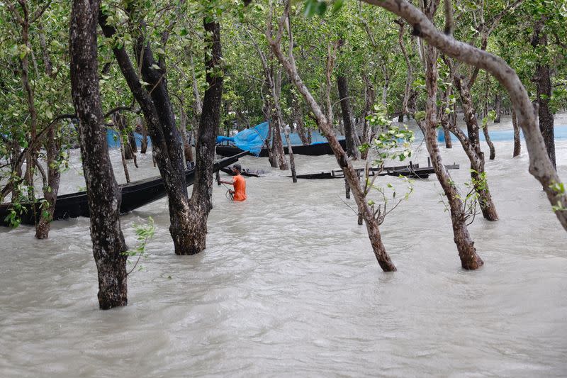 A man moves his boat to tie it to a safer place before the Cyclone Remal hits the country in the Shyamnagar area of Satkhira