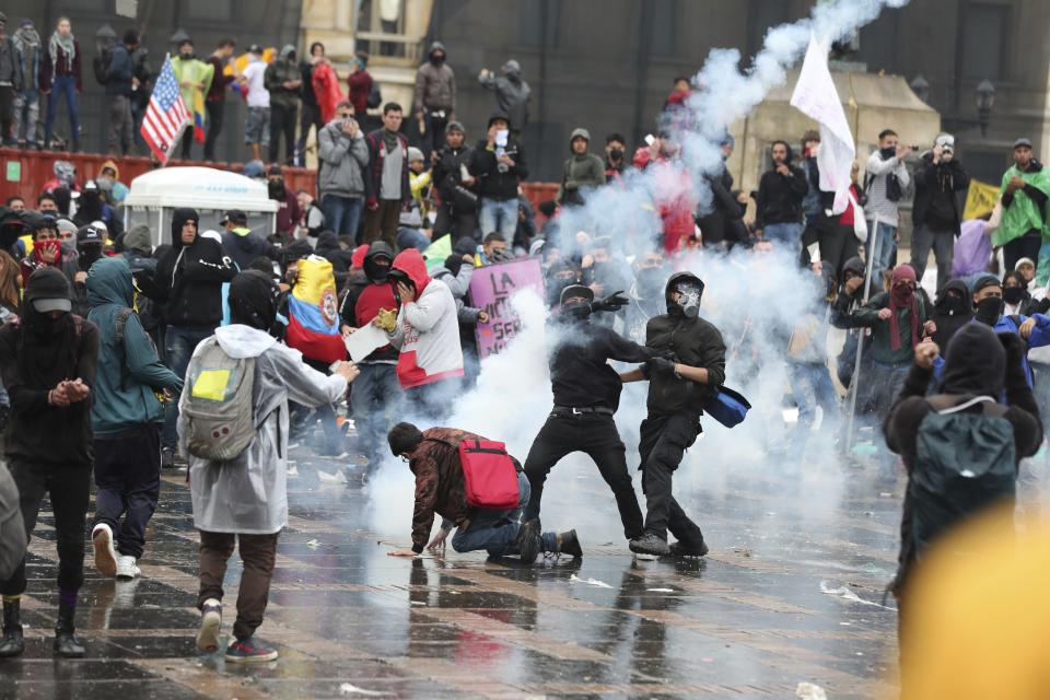 Anti-government protesters clash with the police during a nationwide strike, at Bolivar square in downtown Bogota, Colombia, Thursday, Nov. 21, 2019. Colombia's main union groups and student activists called for a strike to protest the economic policies of Colombian President Ivan Duque government and a long list of grievances. (AP Photo/Fernando Vergara)