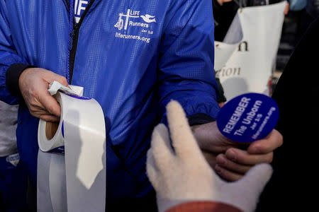 An anti-abortion marcher hands out stickers during the 46th annual March for Life, at the Supreme Court in Washington, U.S., January 18, 2019. REUTERS/Joshua Roberts