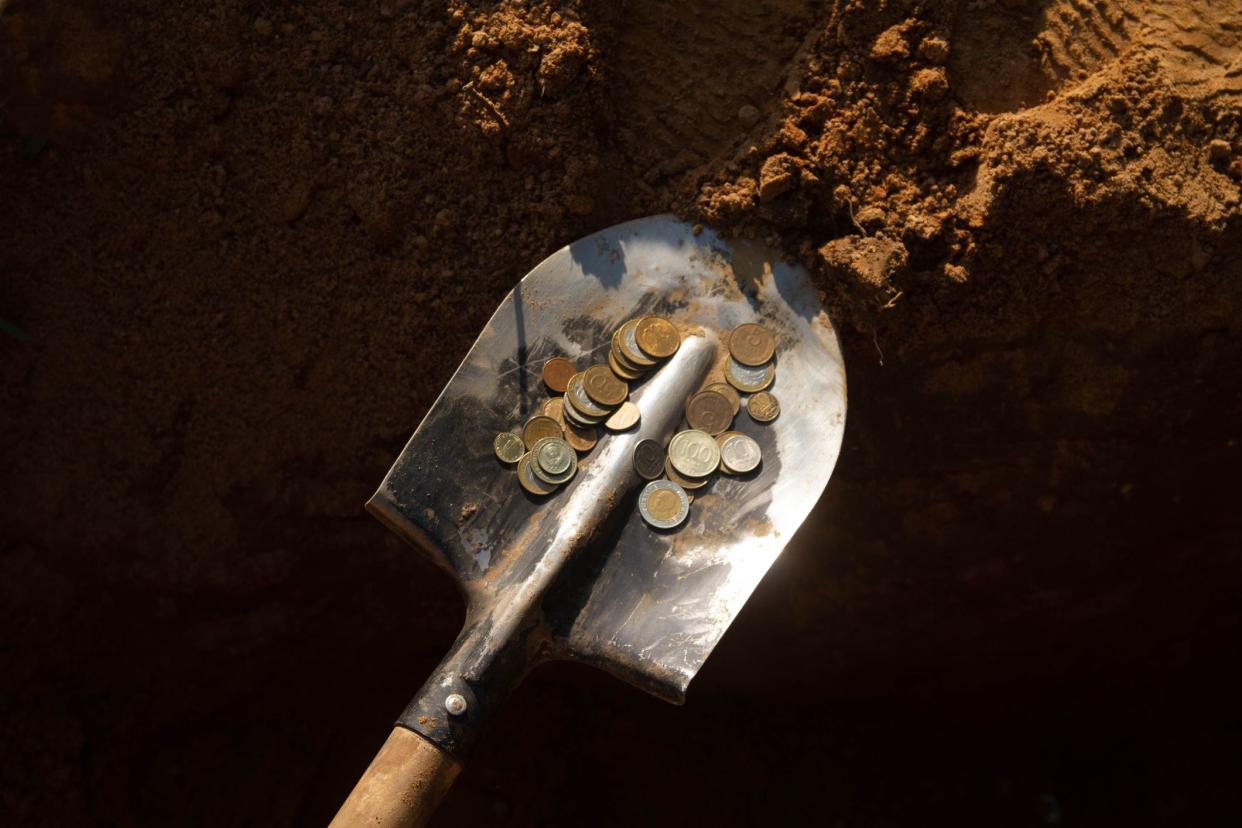 The money is on the shovel. Dig the money out of the ground.