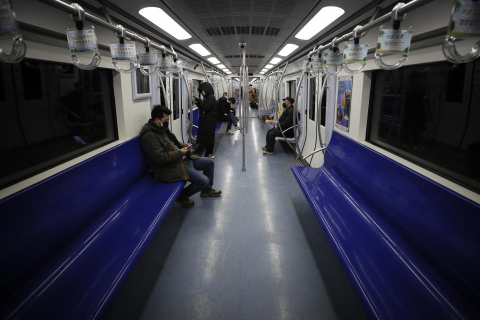 FILE - In this Feb. 17, 2020, file photo, commuters ride in a quiet subway train during the morning rush hour in Beijing. As many Chinese finally go back to work after their longest Lunar New Year holiday ever, the economic fallout from the outbreak of a new coronavirus that began in Wuhan may be just beginning. Companies are warning their bottom lines will take a hit, and governments are ramping up stimulus measures for economies that just weeks ago were hoping to see recoveries after months of uncertainty due to trade tensions and slowing global growth. (AP Photo/Andy Wong, File)