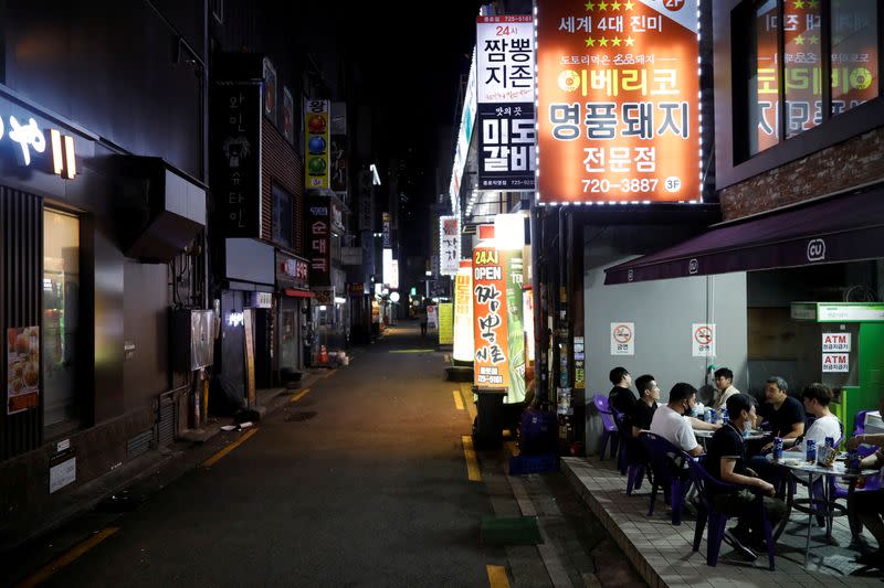 FILE PHOTO: People drink outside in Seoul as tougher social distancing rules continue