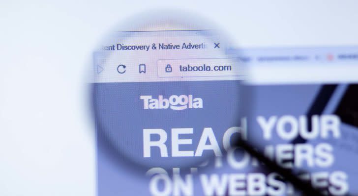 A magnifying glass zooms in on the website for Taboola.