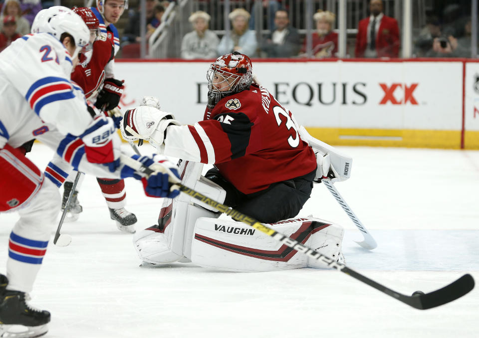 Arizona Coyotes goalie Darcy Kuemper (35) tries to get into position after making a save as New York Rangers center Brett Howden (21) skates in with the puck during the first period of an NHL hockey game, Sunday, Jan. 6, 2019, in Glendale, Ariz. (AP Photo/Ralph Freso)