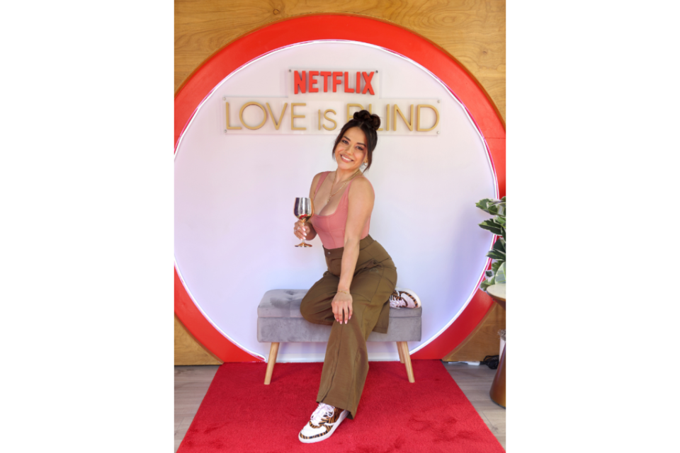 Nancy Rodriguez pictured in front of Netflix's Love Is Blind logo.