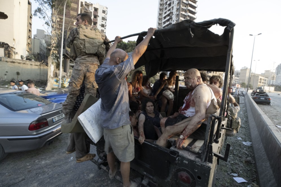 Injured people are rounded up into a military vehicle after the blast in Lebanon's capital.