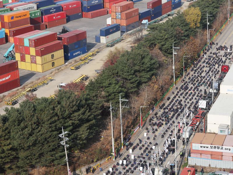 Unionized truckers shout slogans during their rally as they kick off their strike in front of transport hub in Uiwang