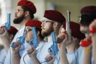 Members of retro gamer Keith Apicary's "security force" stand in formation with video game guns at the PAX East gaming conference in Boston, Massachusetts, April 7, 2012.