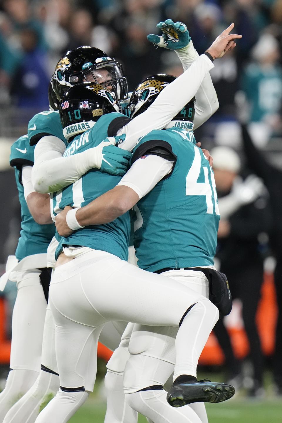 Teammates embrace Jacksonville Jaguars place kicker Riley Patterson (10) after he kicked the game-winning field goal against the Los Angeles Chargers during the second half of an NFL wild-card football game, Saturday, Jan. 14, 2023, in Jacksonville, Fla. Jacksonville Jaguars won 31-30. (AP Photo/Chris O'Meara)