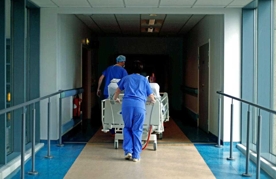 NHS staff with a patient in hospital (AP)