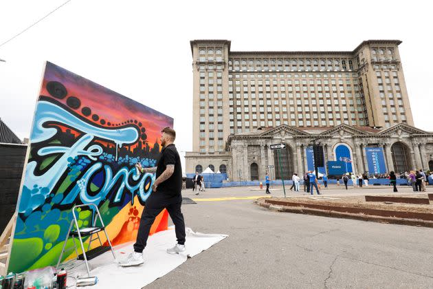 An artist spray paints a canvas at the historic, 105-year old Michigan Central train station prior to a Ford Motor Company press conference to formally announce their plans to renovate the building and turn it and Detroit's Corktown neighborhood into a hub for Ford's auto technology on June 19, 2018 in Detroit, Michigan. (Photo: Bill Pugliano via Getty Images)