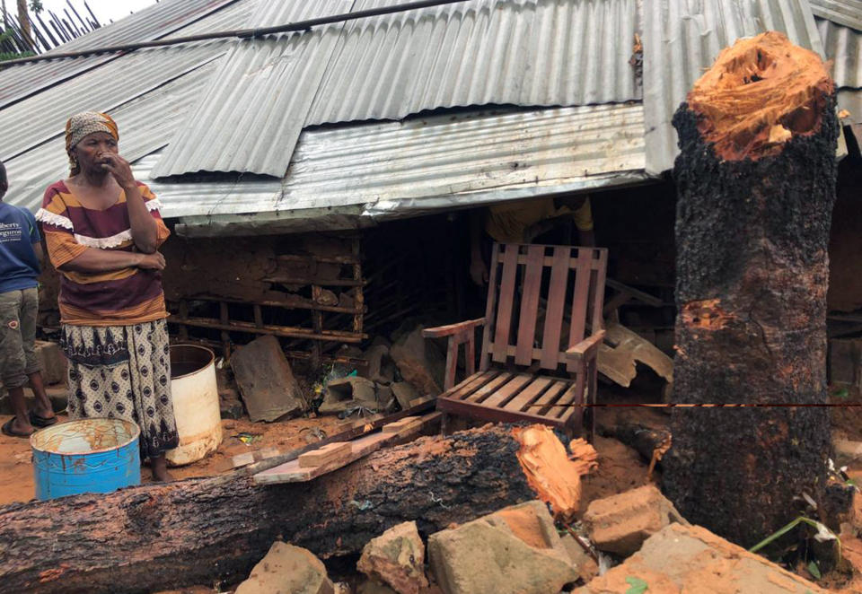 A woman stand next to a collapsed house where a neighbour was killed due to heavy rains in Pemba, Mozambique, Sunday , April 28, 2019. Serious flooding began on Sunday in parts of northern Mozambique that were hit by Cyclone Kenneth three days ago, with waters waist-high in areas, after the government urged many people to immediately seek higher ground. Hundreds of thousands of people were at risk. (AP Photo/Tsvangirayi Mukwazhi)