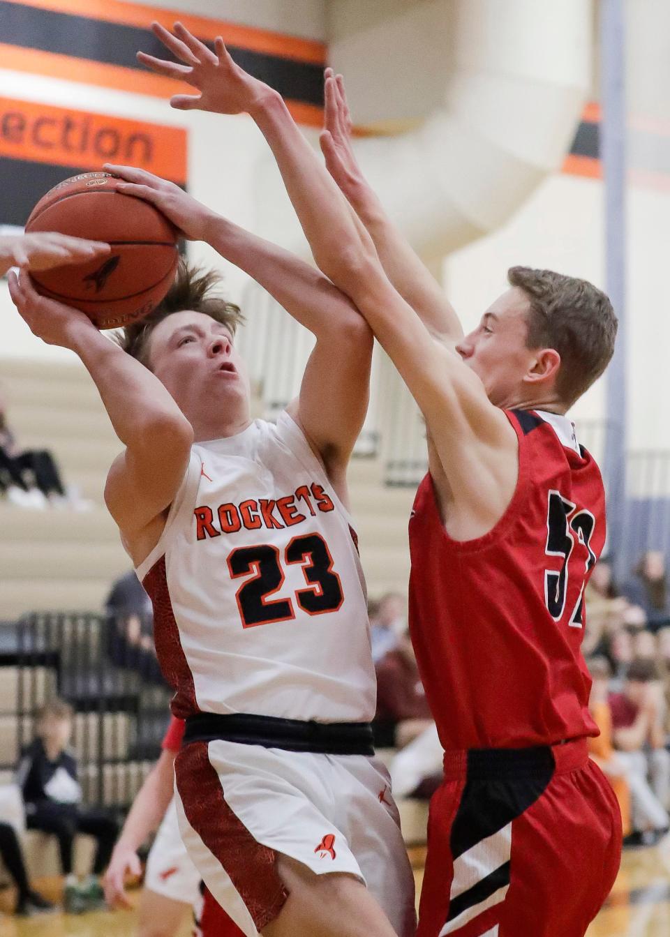 Cedar Grove-Belgium’s Owen Gulke (23) aims by Manitowoc Lutheran’s Noah Lukasek (52), Thursday, December 15, 2022, in Cedar Grove, Wis.