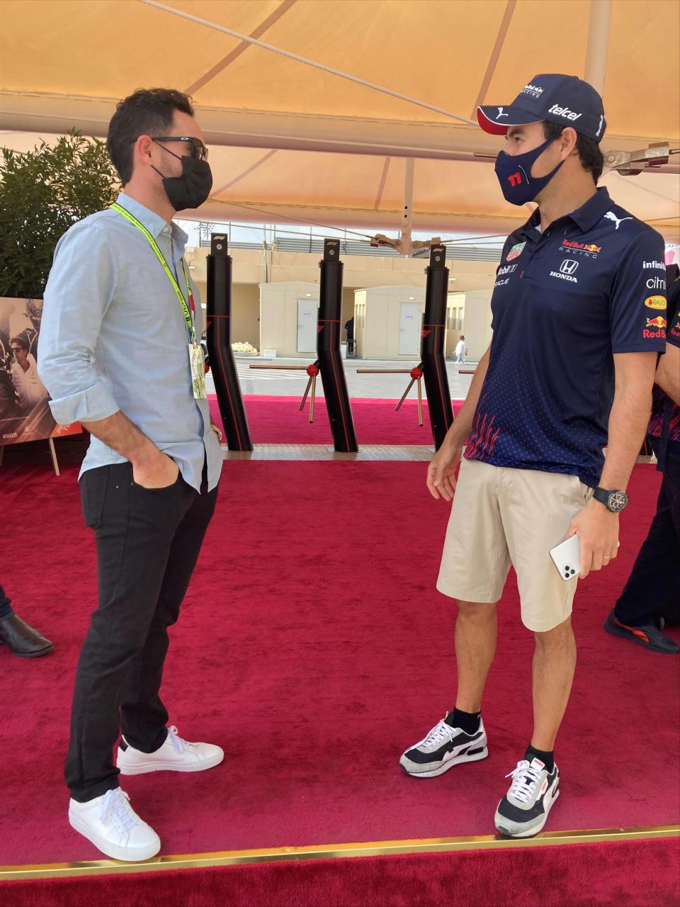 NASCAR champion Kyle Larson, left, talks to Formula One driver Sergio Perez on Sunday, Dec. 12, 2021 at Yas Marina Circuit before the Formula One season-ending Abu Dhabi Grand Prix. Larson attended his first ever F1 race as part of his weeklong visit to Dubai and Abu Dhabi during a vacation following his Cup championship win. (AP Photo/Jenna Fryer)