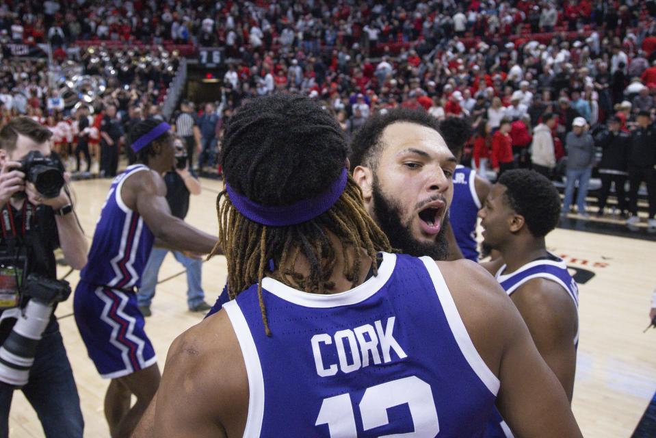 TCU's Xavier Cork (12) and JaKobe Coles (21) celebrate a win over Texas Tech after an NCAA college basketball game, Saturday, Feb. 25, 2023, in Lubbock, Texas. (AP Photo/Chase Seabolt)