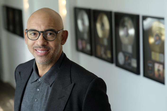 Harvey Mason jr., CEO of The Recording Academy, poses amongst commemorative records he has worked on during his career, at Harvey Mason Media music production studios, Monday, Oct. 11, 2021, in Burbank, Calif. (AP Photo/Chris Pizzello)