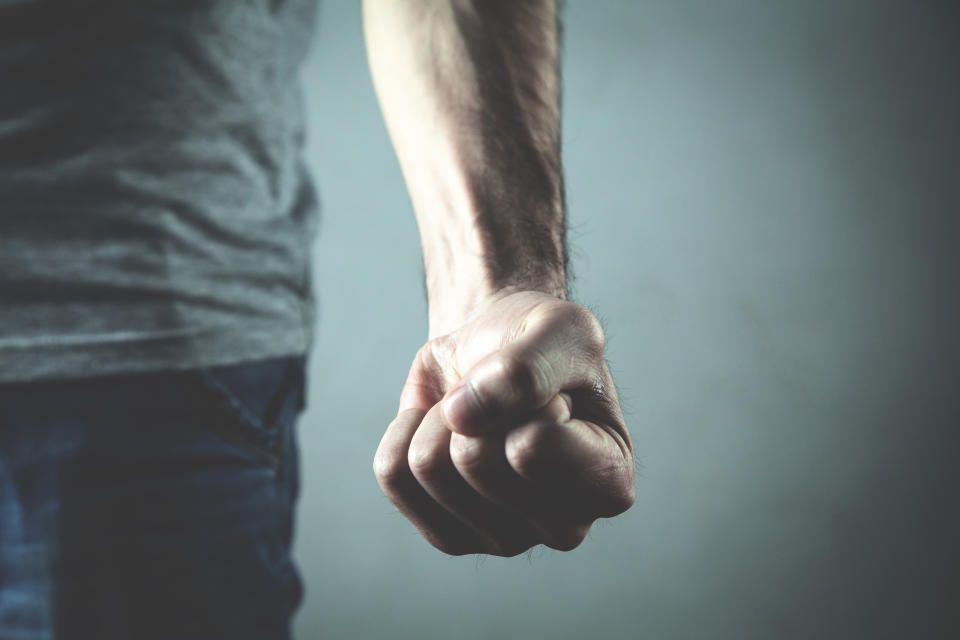 Caucasian angry and aggressive man threatening with fist.