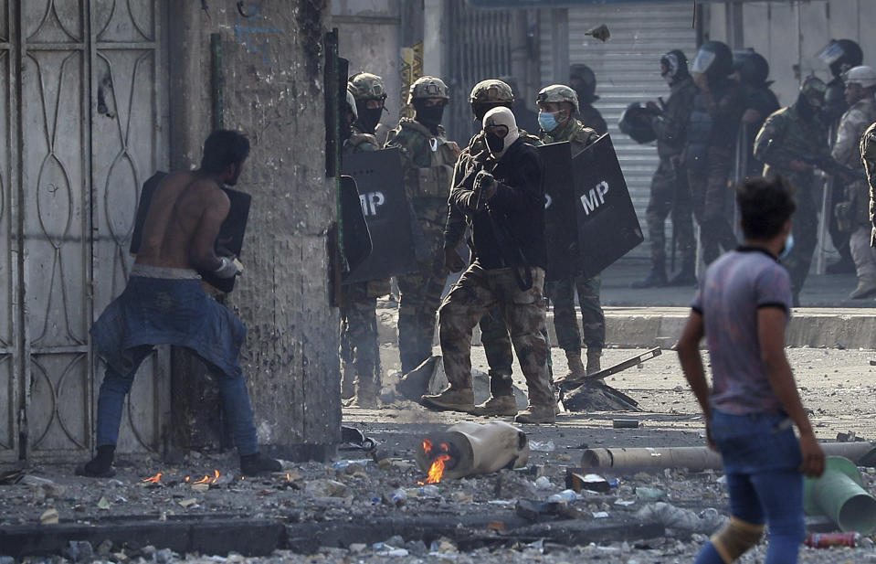 A protester prepares to throw a stone during clashes between Iraqi security forces and anti-government protesters in Baghdad, Iraq, Monday, Nov. 11, 2019. (AP Photo/Hadi Mizban)