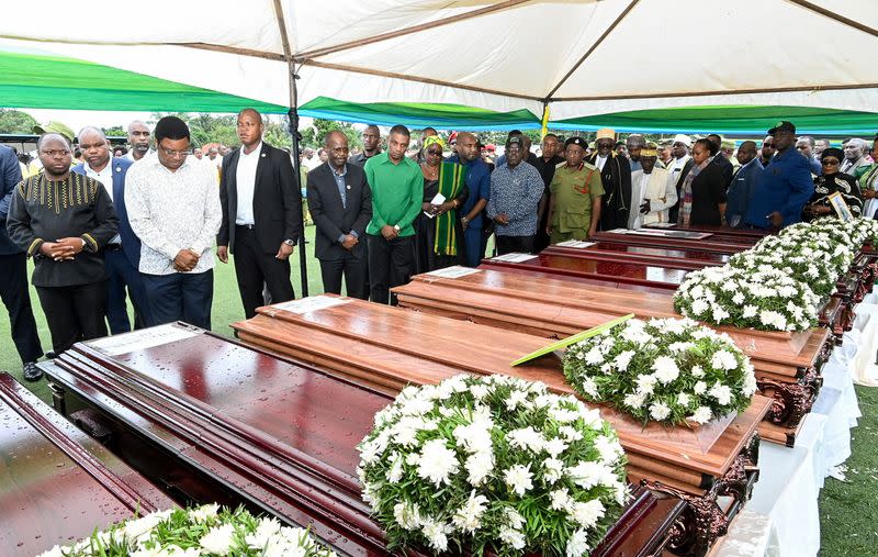 Tanzanian Prime Minister Kassim Majaliwa stands in front of the coffins as he pays homage to the victims following the crash of the Precision Air ATR 42-500 passenger plane into Lake Victoria, at the Kaitaba Stadium in Bukoba