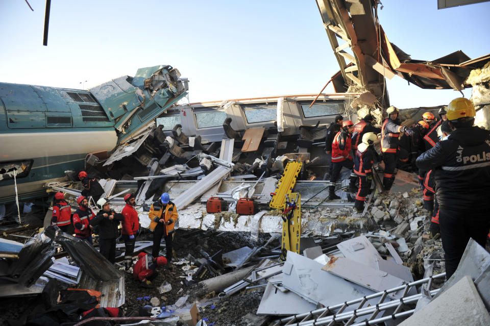 Members of rescue services work at the scene of a train accident in Ankara, Turkey, Thursday, Dec. 13, 2018. A high-speed train hit a railway engine and crashed into a pedestrian overpass at the station in the Turkish capital Thursday, killing several people and injuring scores of others, officials and news reports said. (IHA via AP)