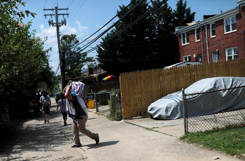 A man helps his relative move belongings out of their damaged house, near the scene of an explosion in a residential area of Baltimore