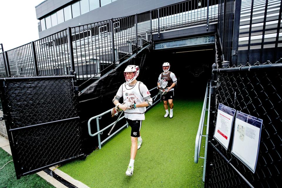 Spencer Graham, left, and Teagan Bultman walk onto the field for practice at Brown.