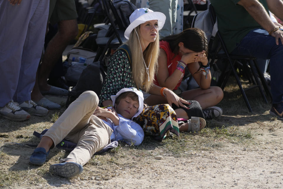 Young pilgrims sit at Parque Tejo in Lisbon where Pope Francis is presiding over a mass celebrating the 37th World Youth Day, Sunday, Aug. 6, 2023. An estimated 1.5 million young people filled the parque on Saturday for Pope Francis' World Youth Day vigil, braving scorching heat to secure a spot for the evening prayer and to camp out overnight for his final farewell Mass on Sunday morning. (AP Photo/Gregorio Borgia)