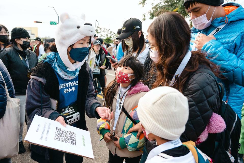 綠色和平志工在「2022國家地理雜誌野生動物路跑」活動中，邀請與會民眾填寫問卷，表達對減塑的期待。