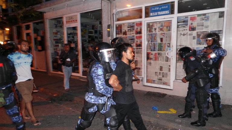 Maldives security personnel arrest opposition activists during an anti-government rally in Male, on May 2, 2015