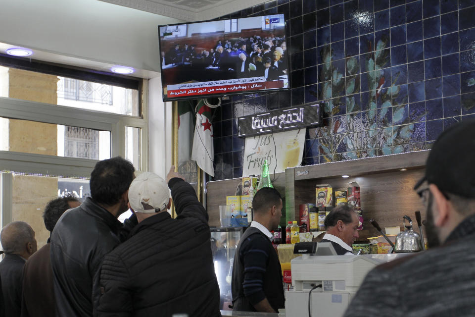 People watch the trial of former Algerian Prime Ministers Ahmed Ouyahia and Abdelmalek Sellal, in a cafe of Algiers, Wednesday, Dec.4, 2019. Ahmed Ouyahia, who was forced out as prime minister in March as protests against President Abdelaziz Bouteflika escalated, and his predecessor Abdelmalek Sellal, are facing questions Wednesday and face corruption charges. (AP Photo/Toufik Doudou)