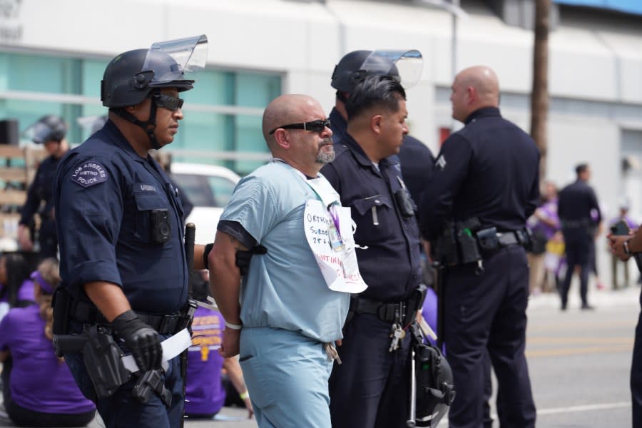 A demonstrator is detained by LAPD officers following a protest outside Kaiser Permanente Hospital in Hollywood on Sept. 4, 2023. (SEIU UHW)