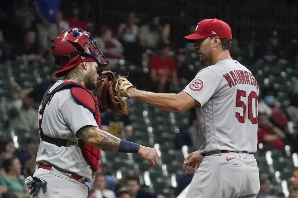 St. Louis Cardinals starting pitcher Adam Wainwright is congratulated by catcher Yadier Molina as he leaves the game during the seventh inning of a baseball game against the Milwaukee Brewers Friday, Sept. 3, 2021, in Milwaukee. The game marks the 300th game that Wainwright and Molina played in together. (AP Photo/Morry Gash)