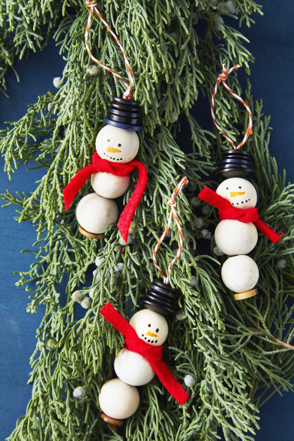 snowman made from craft balls with button hats and a red felt scarf