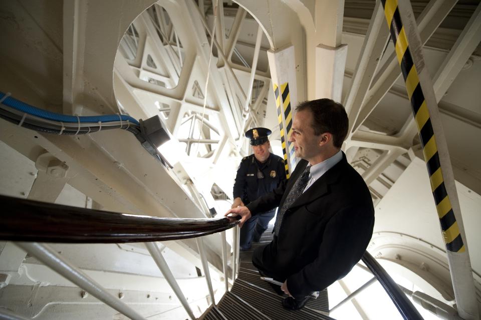 U.S. Capitol staff member and police officer climb steps within the structure of the U.S. Capitol dome during media tour in Washington