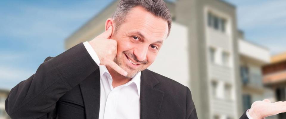 Cheerful realtor holding something in palm and doing call gesture