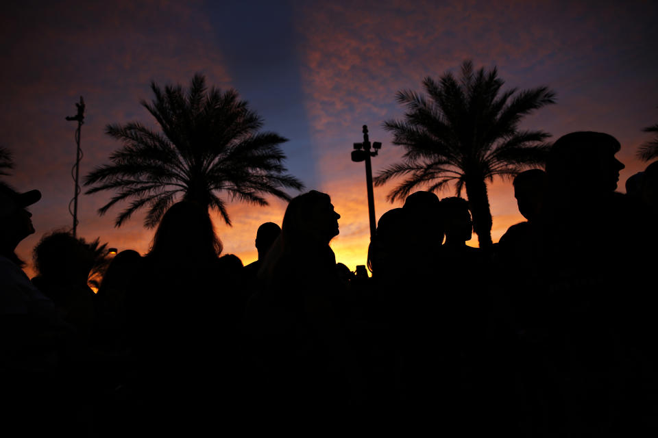 The sun sets as people attend a ceremony to dedicate a memorial garden for victims, Monday, Oct. 1, 2018, on the anniversary of the mass shooting a year earlier, in Las Vegas. (AP Photo/John Locher)