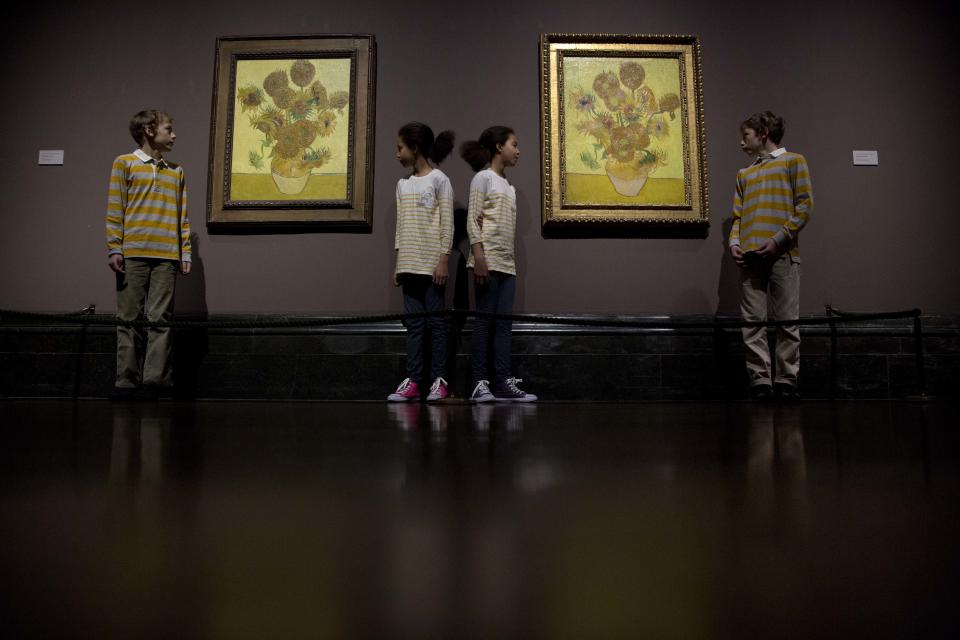 Identical twins Ella, centre left, and Eva, centre right, aged 12, and twins Edgar, left, and Gabriel, aged 10, pose for photographers beside two versions of Dutch-born painter Vincent van Gogh's "Sunflowers", the left one from 1888 and the right one from 1889, during a photocall at the National Portrait Gallery in London, Friday, Jan. 24, 2014. The two paintings are being reunited in London for the first time in 65 years, with the 1889 version on loan from the Van Gogh Museum in Amsterdam. They will be displayed together until April 27. (AP Photo/Matt Dunham)