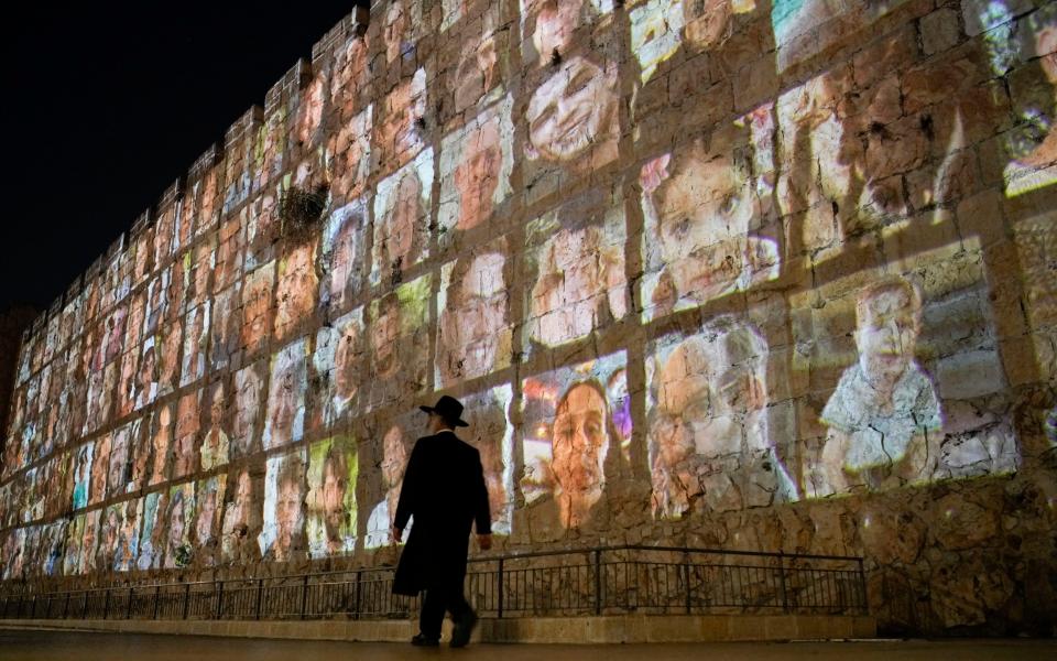Photographs of Israeli hostages being held by Hamas militants are projected on the walls of Jerusalem's Old City