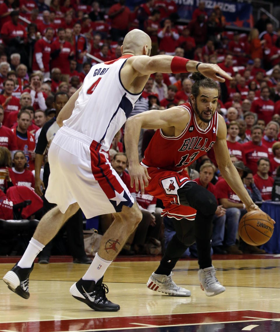 Chicago Bulls center Joakim Noah (13) drives past Washington Wizards center Marcin Gortat (4), from Poland, in the first half of Game 3 of an opening-round NBA basketball playoff series on Friday, April 25, 2014, in Washington. (AP Photo/Alex Brandon)