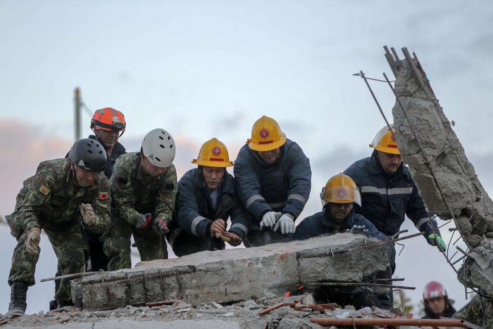 Rescuers remove debris from a damaged building in Durres, western Albania, Wednesday, Nov. 27, 2019. The death toll from a powerful earthquake in Albania has risen to 25 overnight as local and international rescue crews continue to search collapsed buildings for survivors. (AP Photo/Visar Kryeziu)