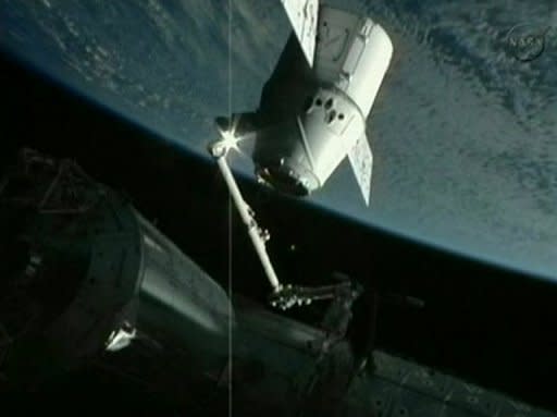 This frame grab from a NASA video shows the robotic arm of the ISS grappling SpaceX's Dragon capsule on May 25. The station's robotic arm, which grabbed the capsule on its approach May 22, has already been re-grappled to the Dragon, she said