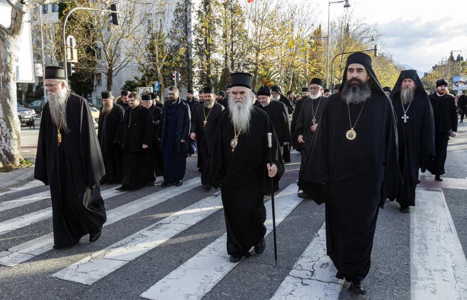 Serbian Orthodox Church clergy in Montenegro march as they protest the planned adoption of a religious law that they say will pave the way to strip the church of its property, in Podgorica, Montenegro, Tuesday, Dec. 24, 2019. Montenegro's pro-Western president has accused the church of promoting pro-Serb policies in Montenegro and seeking to undermine the country's statehood since it split from Serbia in 2006. (AP Photo/Risto Bozovic)